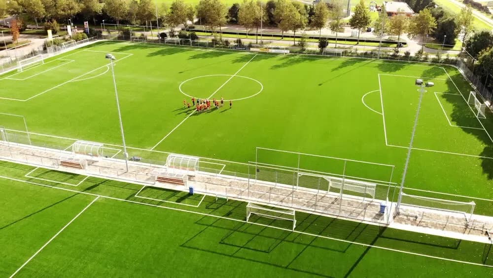 Sportpark met betonverharding langs het veld